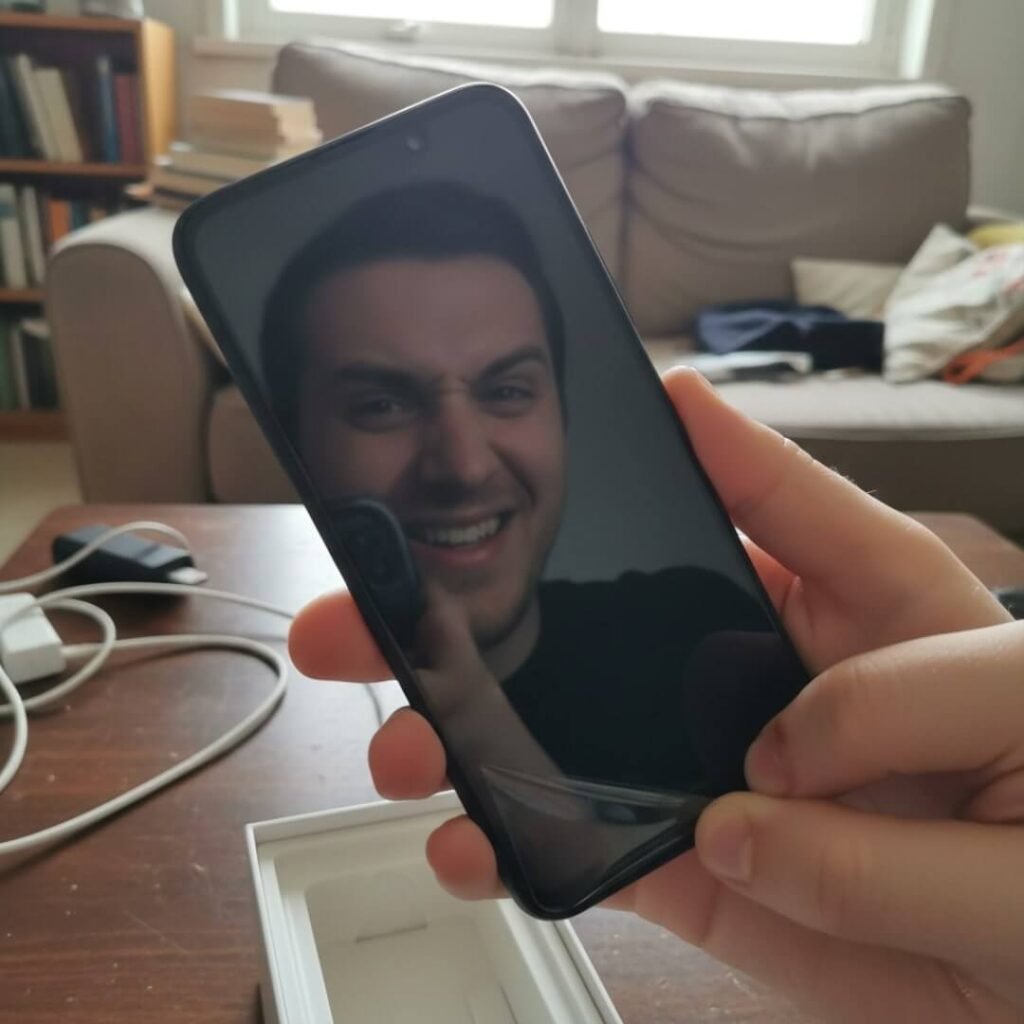 Reflection of skeptical face unboxing new phone.